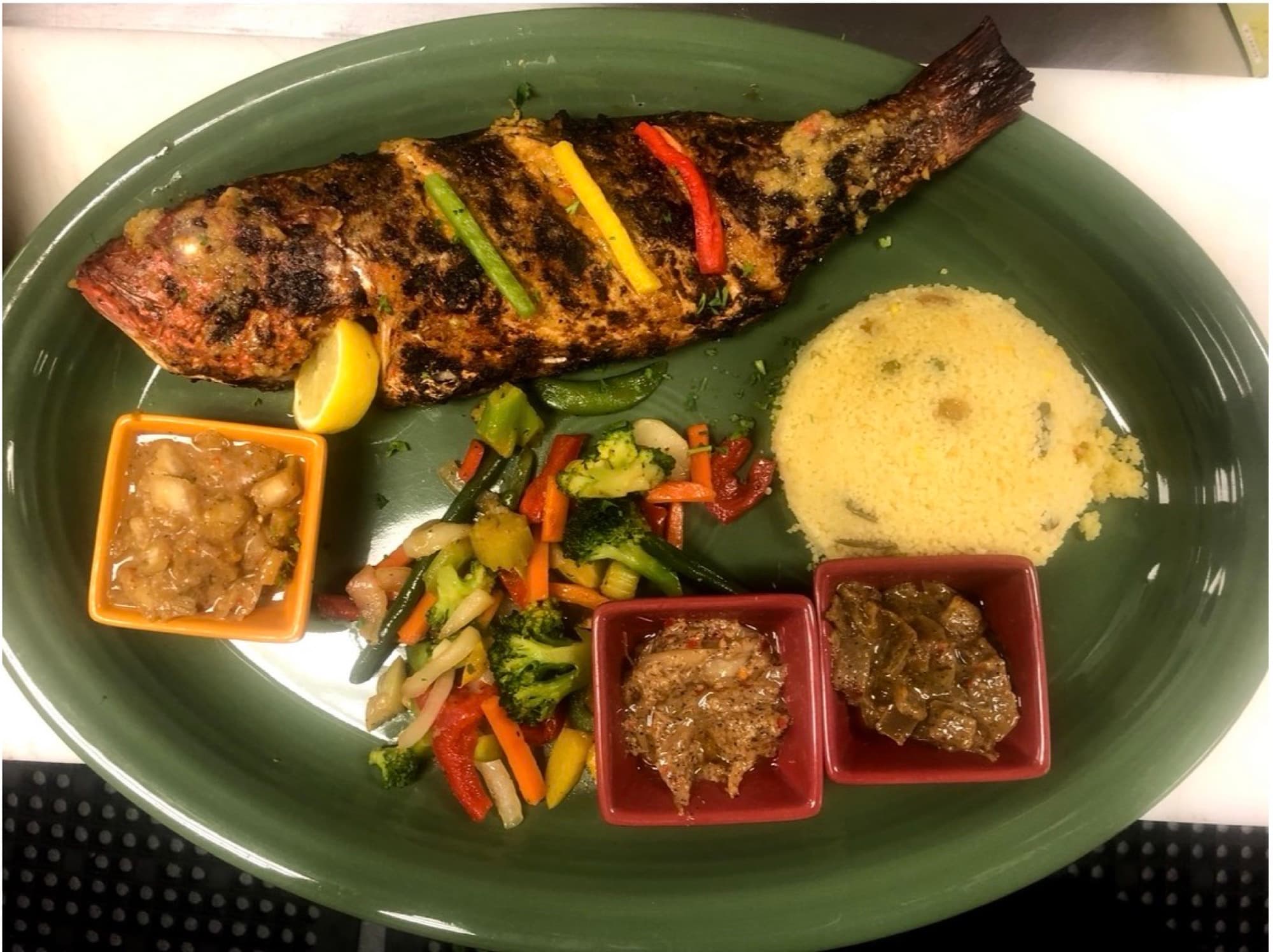 Catering platter — whole grilled fish with couscous, sautéed vegetables and house sauces